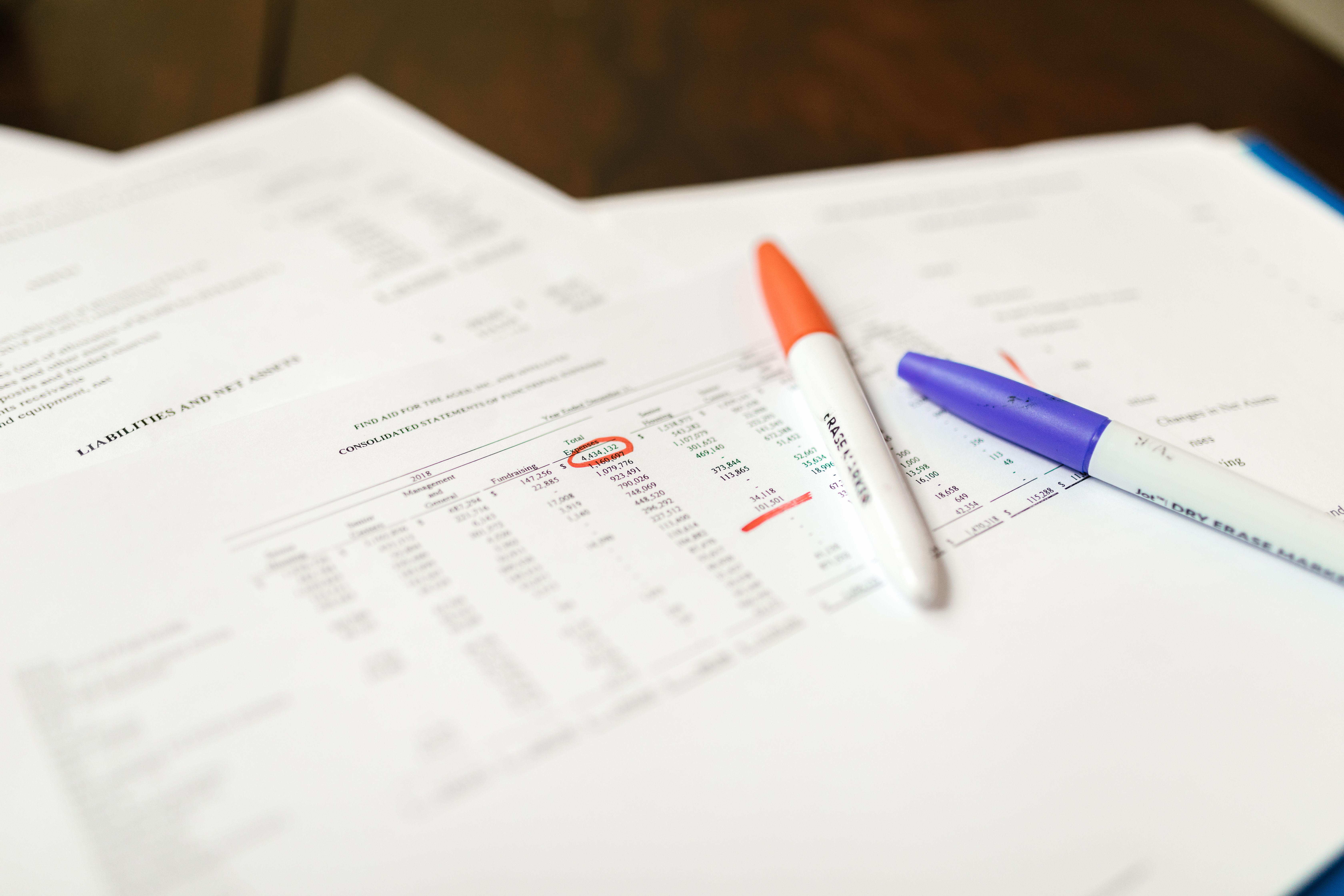 A close-up of a financial document with two pens on top